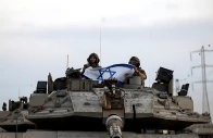 israeli soldiers hold an israeli flag while in a tank near israel s border with the gaza strip in southern israel october 12 2023 photo reuters