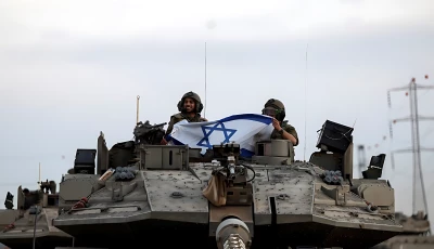 israeli soldiers hold an israeli flag while in a tank near israel s border with the gaza strip in southern israel october 12 2023 photo reuters