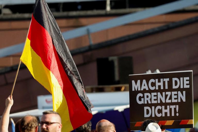 a person holds a poster reading close the borders during a right wing alternative for germany afd party protest one week after a man killed a policeman with a knife in the city of mannheim germany june 7 2024 photo reuters