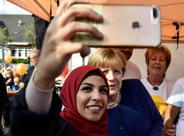 a syrian refugee with former chancellor of germany photo file