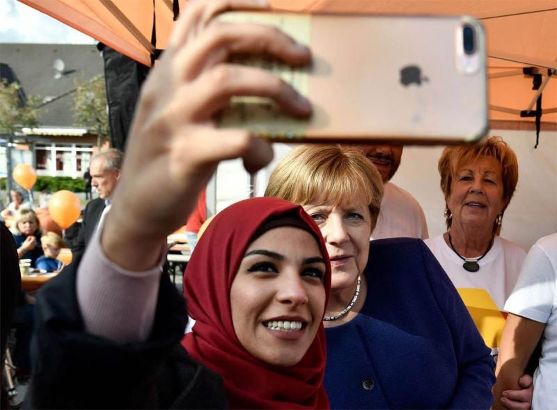 a syrian refugee with former chancellor of germany photo file