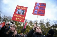 people carry placards featuring images of german chancellor friedrich merz during a nationwide protest by campaign group gen z regelt gen z takes charge against underfunding of schools cuts to education social services culture and healthcare rising living costs and military conscription in berlin germany october 31 2026 reuters