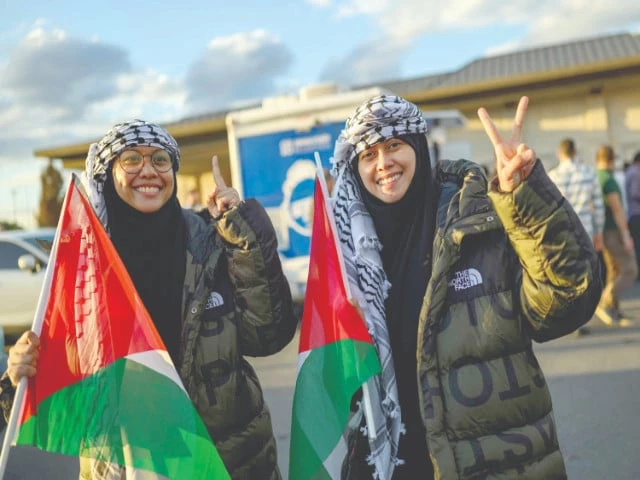 sisters nur heliza helmi l and nur hazwani afiqah binti helmi two of the activists who were sailing aboard vessels from the global sumud flotilla make a victory sign after arriving with thirty six turks and nationals from 12 countries at istanbul airport photo afp
