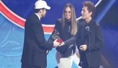 bad bunny accepts the award for best urban song for deb tirar m s fotos from presenters daisy fuentes and richard marx at the 26th annual latin grammy awards in las vegas photo reuters
