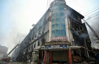 fire fighters and rescue workers perform a cooling operation amid the debris after a massive fire at a shopping mall in karachi on january 19 2026 afp
