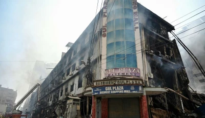 fire fighters and rescue workers perform a cooling operation amid the debris after a massive fire at a shopping mall in karachi on january 19 2026 afp