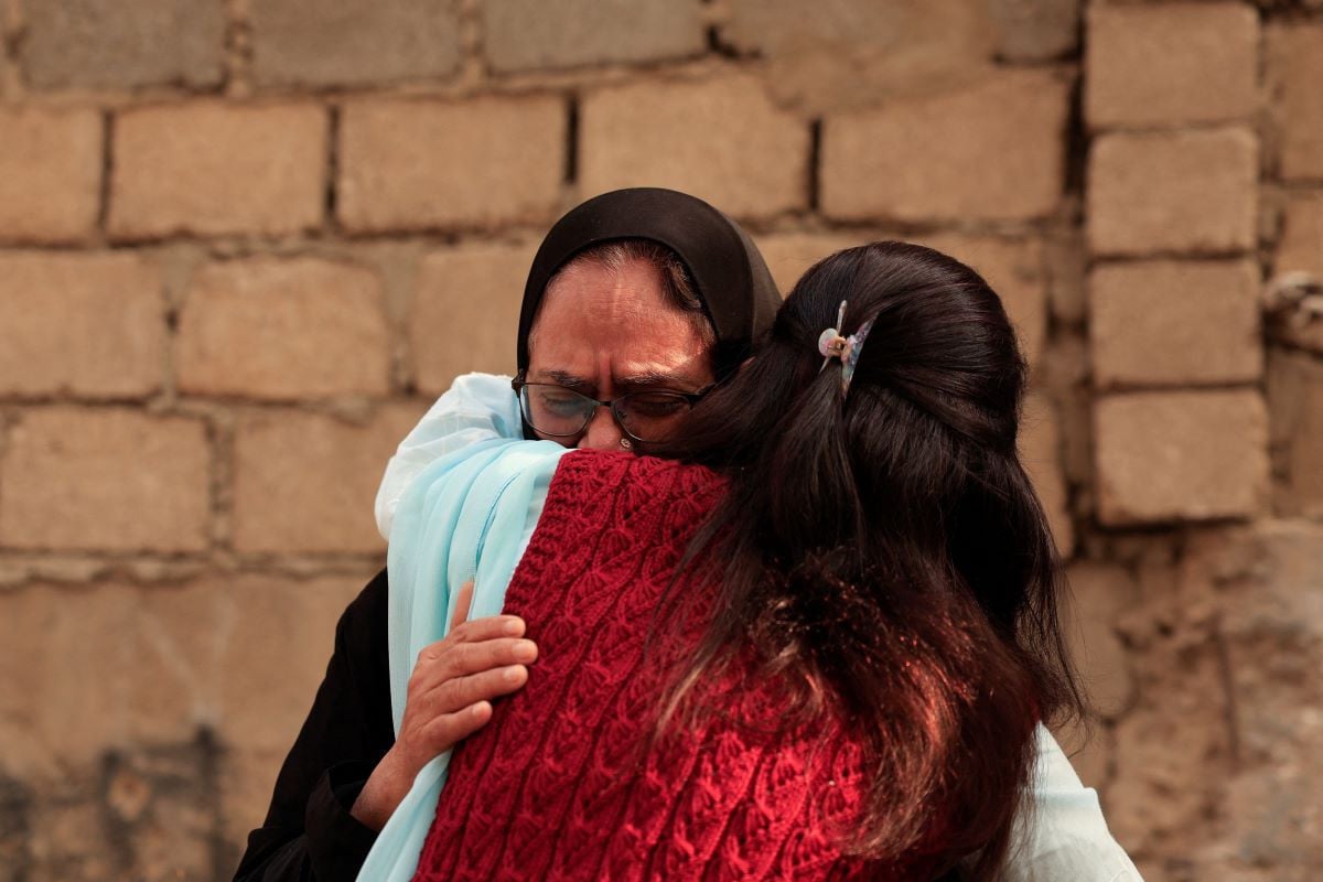 A woman is comforted as she mourns six missing family members who were there shopping for a wedding ceremony, following a massive fire that broke out in the Gul Plaza Shopping Mall in Karachi, Pakistan, January 19, 2026.PHOTO: REUTERS