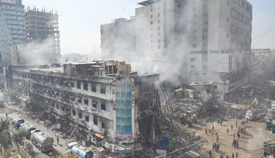 rescue workers search amid the debris using excavators after a massive fire at a shopping mall in karachi photo afp