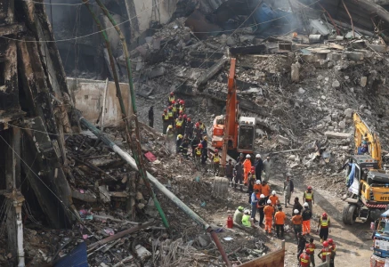 rescue and emergency team members gather near heavy machinery before starting their search for survivors following a massive fire that broke out in the gul plaza shopping mall in karachi on january 22 photo reuters