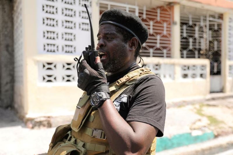 former police officer jimmy barbecue cherizier and leader of an alliance of armed groups uses a walkie talkie after addressing the media in port au prince haiti march 11 2024 photo reuters