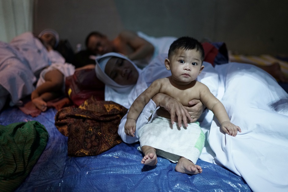 One year old Indonesian boy Samsirul Rizki bin Samirudin sits beside his mother as pilgrims begin gathering in Arafat to mark Hajj's most important day, Day of Arafat. PHOTO: Reuters