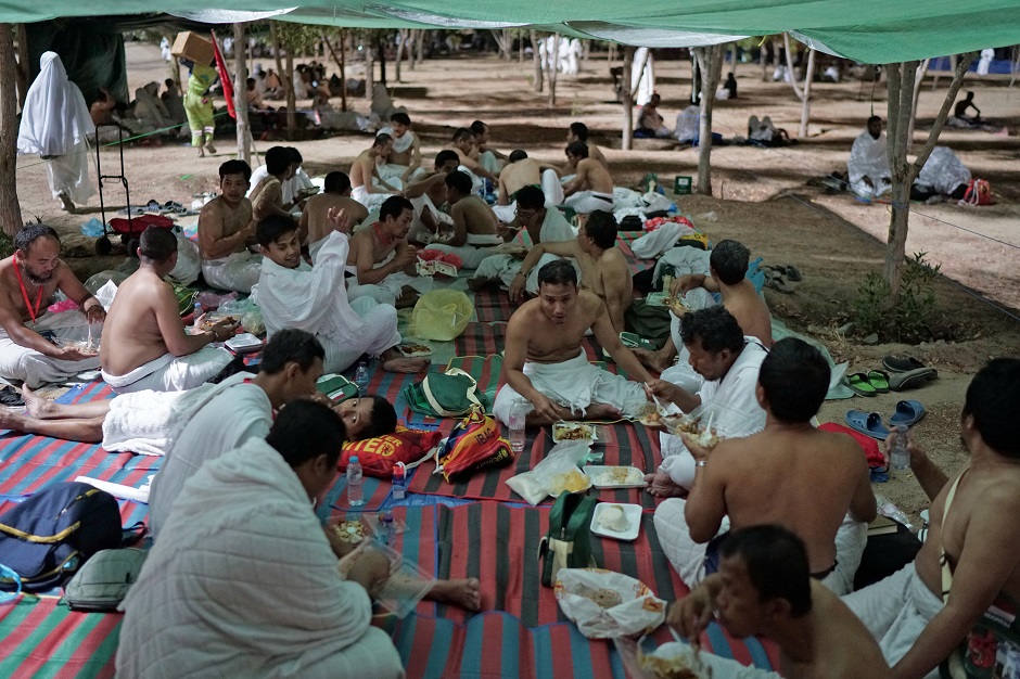 Pilgrims eat as they begin gathering in Arafat to mark Hajj's most important day. PHOTO: Reuters