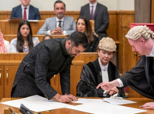 humza yousaf signs the parchments as he is sworn in as first minister of scotland at the court of session edinburgh picture date wednesday march 29 2023 photo reuters