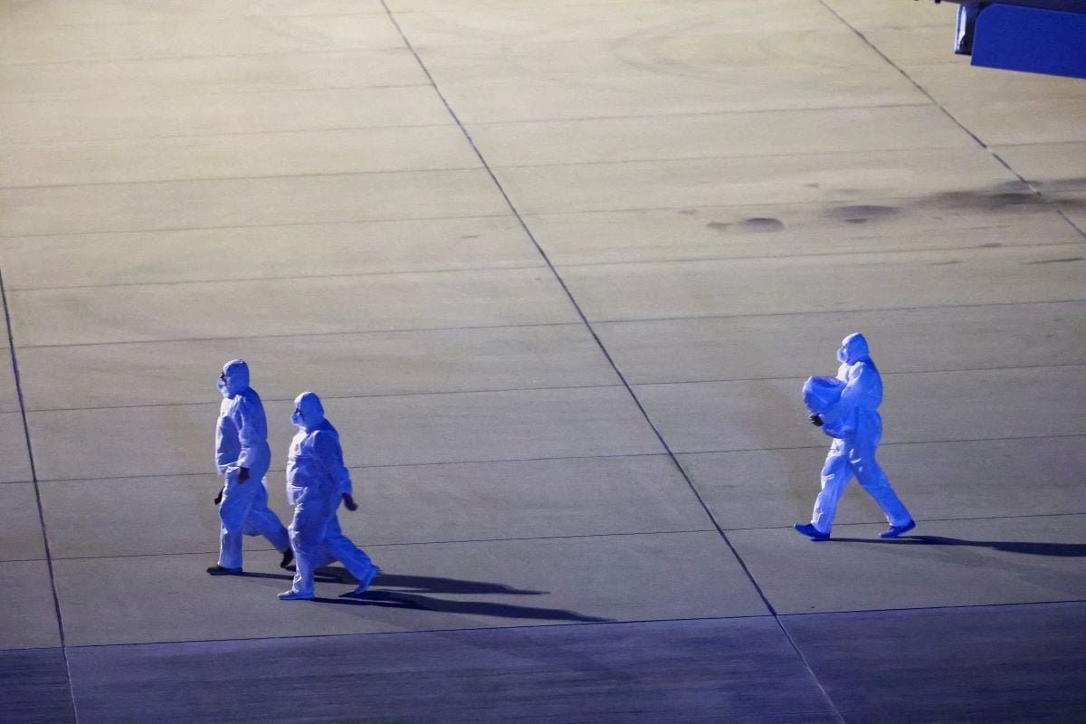 Personnel in hazmat suits walk near a plane carrying passengers evacuated from the cruise ship MV Hondius, which was affected by a hantavirus outbreak, after it landed at the Eindhoven Air Base in Eindhoven, Netherlands May 12, 2026. PHOTO: REUTERS