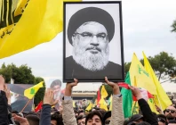 a protester hoists a framed portrait of slain hezbollah leader hassan nasrallah in front of lebanese troops during a riot organized by the terror group outside the airport in beirut lebanon february 15 2025 photo afp