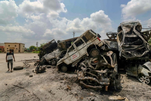 a man walks past burned vehicles after violent clashes in nuh near the indian capital new delhi photo afp a man walks past burned vehicles after violent clashes in nuh near the indian capital new delhi photo afp