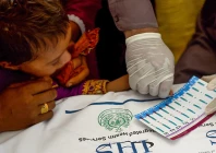 paramedic takes blood samples from a child for a hiv test at a state run hospital in rato dero in the district of larkana photo afp