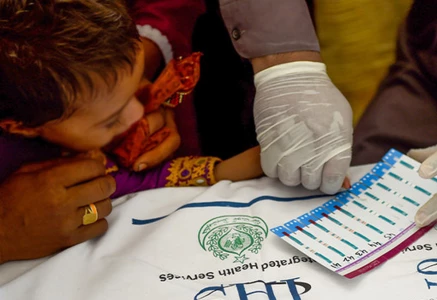 paramedic takes blood samples from a child for a hiv test at a state run hospital in rato dero in the district of larkana photo afp
