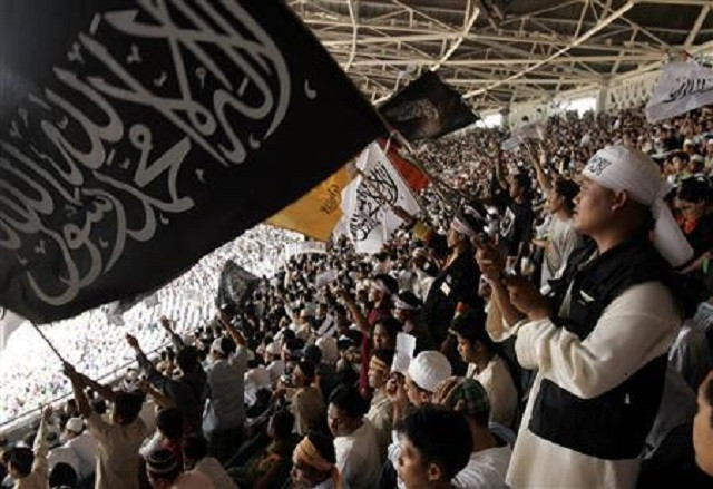 a member of hizbut tahrir indonesia waves a flag at the international caliphate conference at bung karno stadium in jakarta august 12 2007 photo reuters