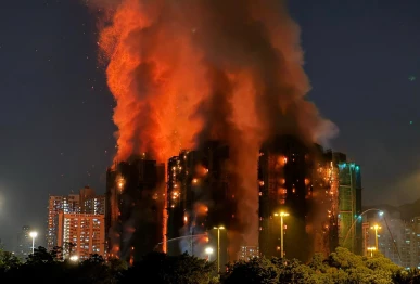 thick smoke and flames rise as a major fire engulfs several apartment blocks at the wang fuk court residential estate in hong kong s tai po district on november 26 2025 at least four people were killed when a fire engulfed several high rise blocks in a hong kong residential estate on november 26 the government said with media reporting that some residents were trapped inside photo afp