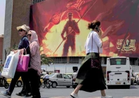 bustling city women walk past a political billboard at valiasr square in central tehran photo afp