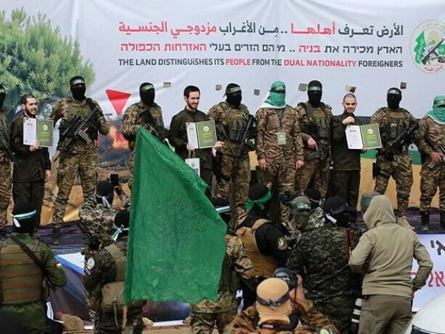 hamas fighters parade newly released israeli hostages l to r elia cohen omer shem tov and omer wankert on stage in nuseirat in the central gaza strip as part of the seventh hostage prisoner release on february 22 2025 photo afp hamas fighters parade newly released israeli hostages l to r elia cohen omer shem tov and omer wankert on stage in nuseirat in the central gaza strip as part of the seventh hostage prisoner release on february 22 2025 photo afp