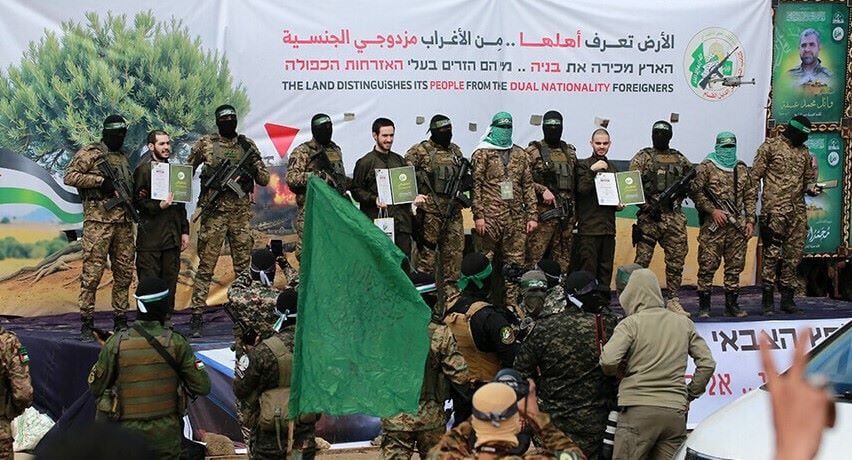 hamas fighters parade newly released israeli hostages l to r elia cohen omer shem tov and omer wankert on stage in nuseirat in the central gaza strip as part of the seventh hostage prisoner release on february 22 2025 photo afp