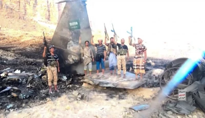 houthi fighters stand in front of what they say is a downed saudi jet at a location given as yemen photo houthi military media handout via reuters