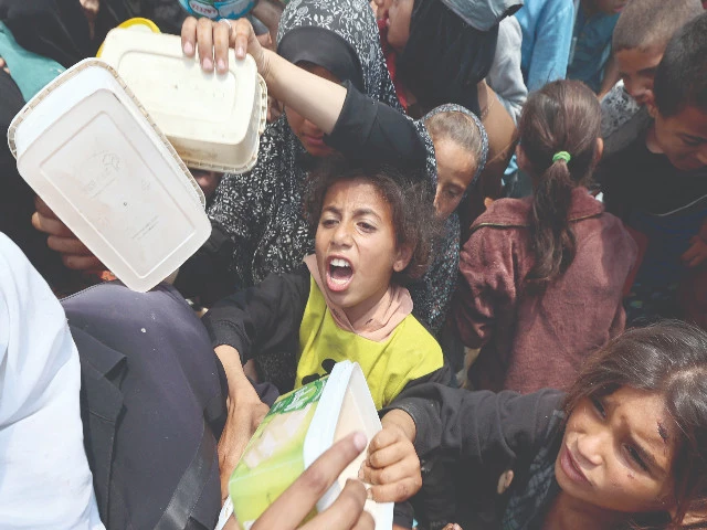 a palestinian girl reacts as people gather for a hot meal at a food distribution point in the nuseirat camp for refugees in gaza photo afp a palestinian girl reacts as people gather for a hot meal at a food distribution point in the nuseirat camp for refugees in gaza photo afp