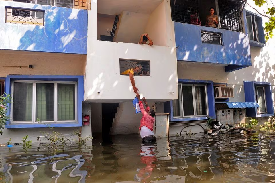a volunteer offers food to a resident after his house got partially submerged following heavy rains due to cyclone michaung in chennai india december 6 2023 photo reuters file