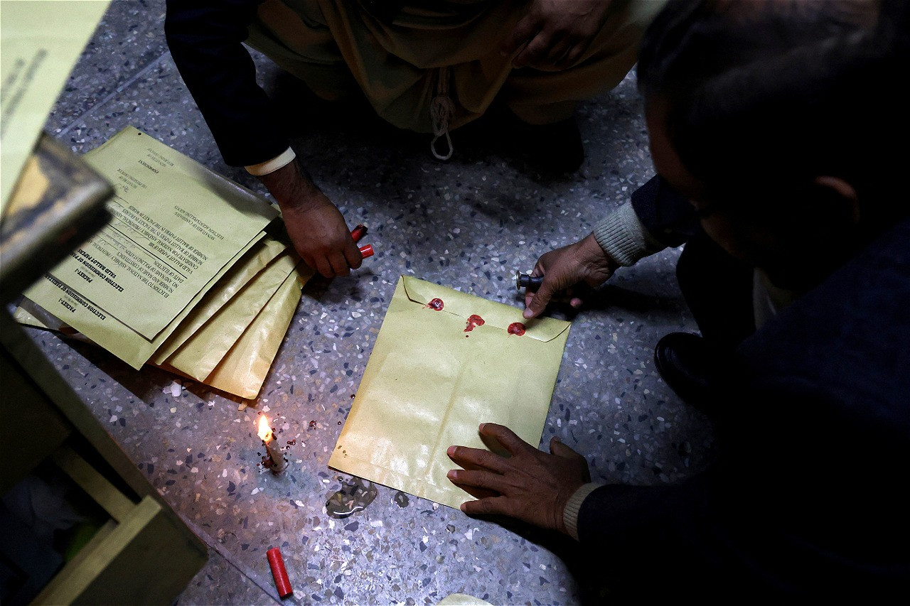 workers seal election papers with wax at a polling station in a school during the general election in islamabad february 8 2024 photo reuters