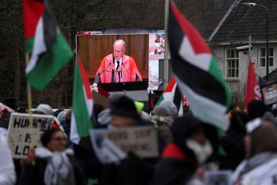 a view of a live broadcast displayed on a street as pro palestinian demonstrators protest near the international court of justice icj on the day judges hear a request for emergency measures to order israel to stop its military actions in gaza in the hague netherlands january 11 2024 photo reuters