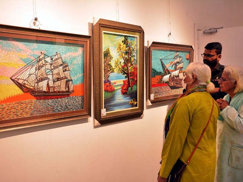 art enthusiasts look on to the paintings by karachi central jail prisoners on display at the arts council of pakistan photo express tribune