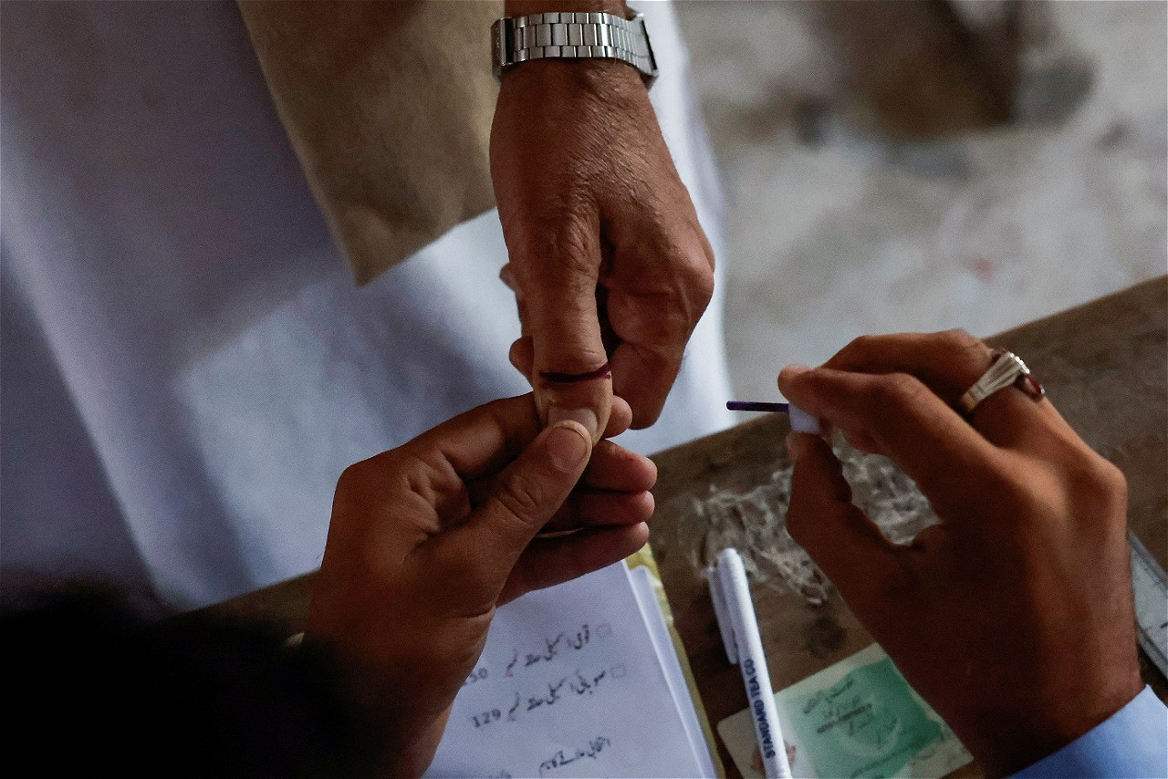 a voter gets an ink mark on his thumb after casting his vote during the general election in karachi photo reuters