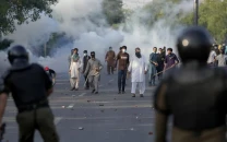 supporters of pakistan tehreek e insaf pti supremo imran khan throw stones after police fire tear gas to disperse them in lahore on may 9 2023 file photo