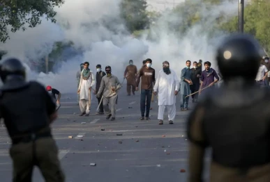 supporters of pakistan tehreek e insaf pti supremo imran khan throw stones after police fire tear gas to disperse them in lahore on may 9 2023 file photo