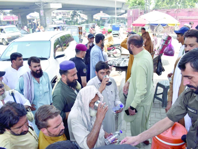 staff members distribute cold drinks to pedestrians at a heat response unit set up by the peshawar administration photo express staff members distribute cold drinks to pedestrians at a heat response unit set up by the peshawar administration photo express