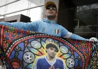 a fan displays a flag bearing the image of argentine football legend diego maradona outside the court on october 8 2026 photo afp