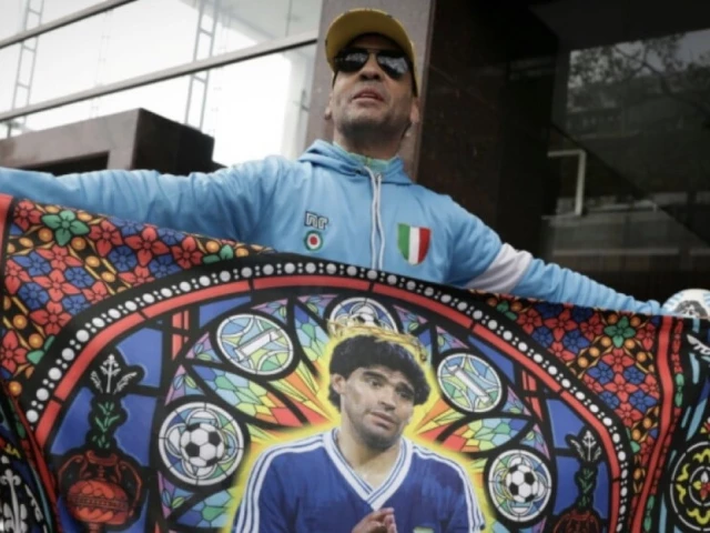 a fan displays a flag bearing the image of argentine football legend diego maradona outside the court on october 8 2026 photo afp a fan displays a flag bearing the image of argentine football legend diego maradona outside the court on october 8 2026 photo afp