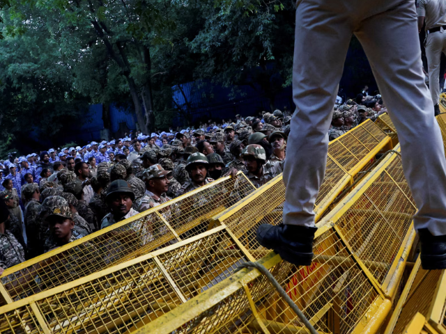 Police and security personnel stand guard behind barricades as opposition parties march to the Supreme Court to protest a controversial revision of voter lists that has sparked days of unrest, in New Delhi, India, October 12, 2026. PHOTO: Reuters