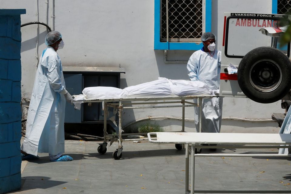 Mortuary workers load the body of a person, who died from the coronavirus disease (COVID-19), to an ambulance for cremation, at a hospital in New Delhi, India May 5, 2021. REUTERS