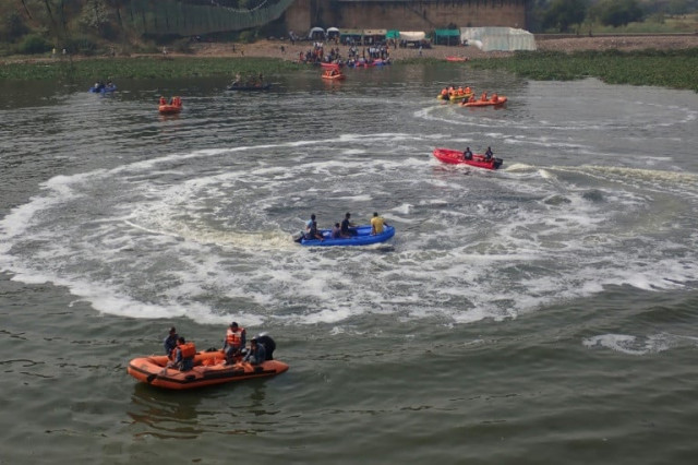 rescue workers search for bodies in the river after the collapse of the bridge in india photo afp rescue workers search for bodies in the river after the collapse of the bridge in india photo afp