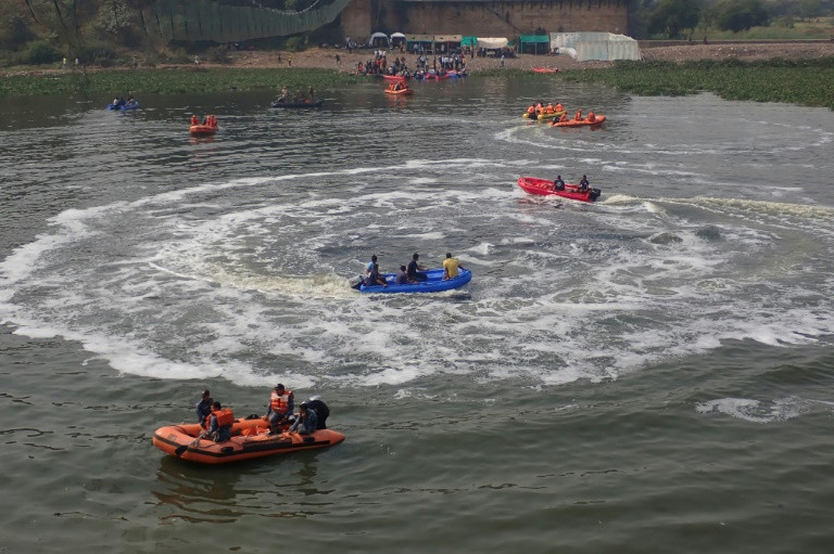 rescue workers search for bodies in the river after the collapse of the bridge in india photo afp