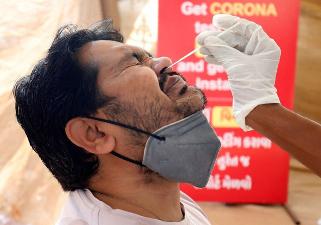 a man reacts as a healthcare worker collects a swab sample from him to test for the coronavirus disease covid 19 at a kiosk in ahmedabad india december 6 2021 photo reuters a man reacts as a healthcare worker collects a swab sample from him to test for the coronavirus disease covid 19 at a kiosk in ahmedabad india december 6 2021 photo reuters