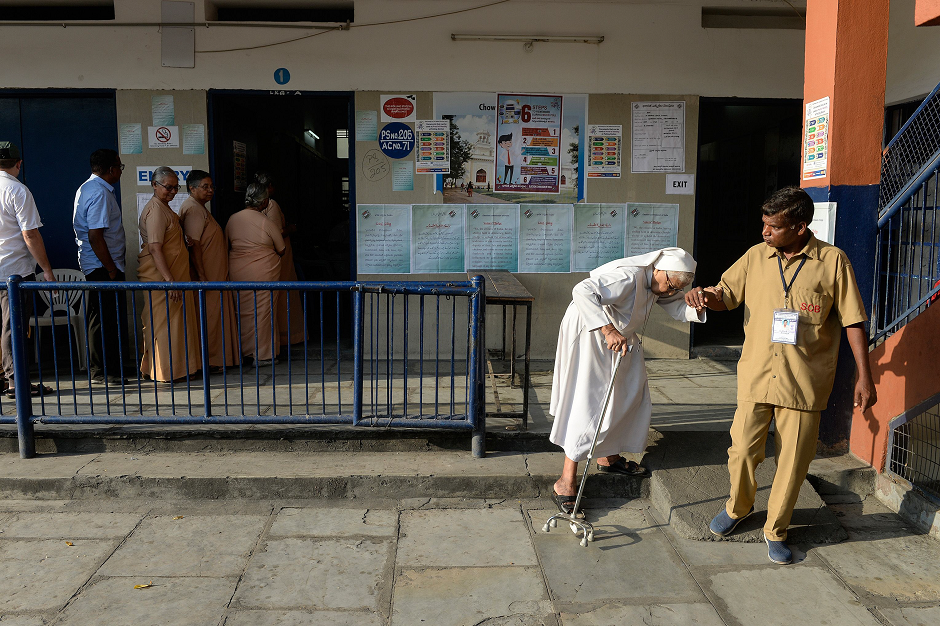 A Catholic nun is assisted as she leaves a polling station after voting during India's general election in Hyderabad on April 11, 2019. PHOTO: AFP