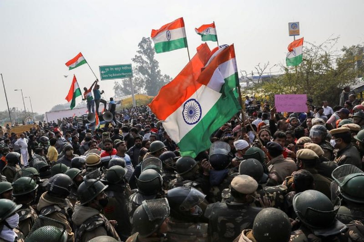 people shout anti farmers slogans and wave india s flags as police officers try to stop them at a site of the protest against farm laws at singhu border near new delhi india january 29 2021 reuters