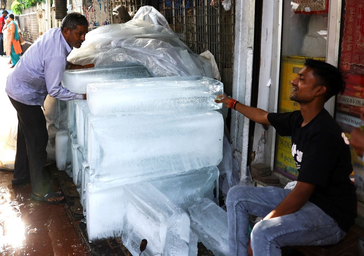 A man moves blocks of ice for sale in a market on a hot summer day in Old Delhi, India, May 22, 2026. REUTERS