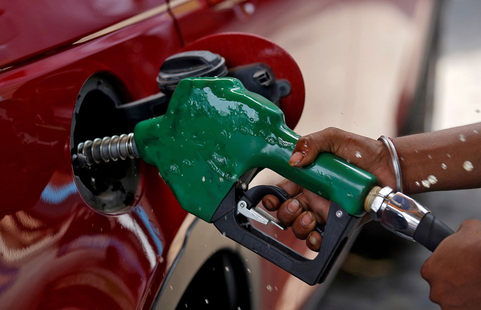 a worker holds a nozzle to pump petrol into a vehicle at a fuel station in mumbai india may 21 2018 photo reuters file