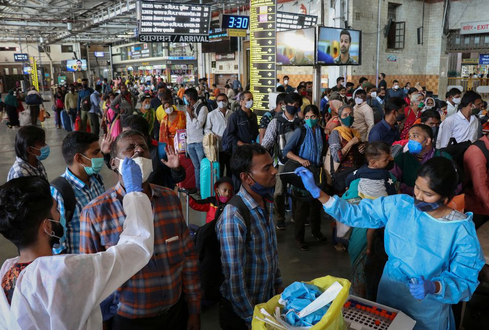 healthcare workers collect swab samples from passengers as others wait for their turn upon arrival at a railway station during a rapid antigen testing drive for the coronavirus disease covid 19 in mumbai india november 29 2021 photo reuters