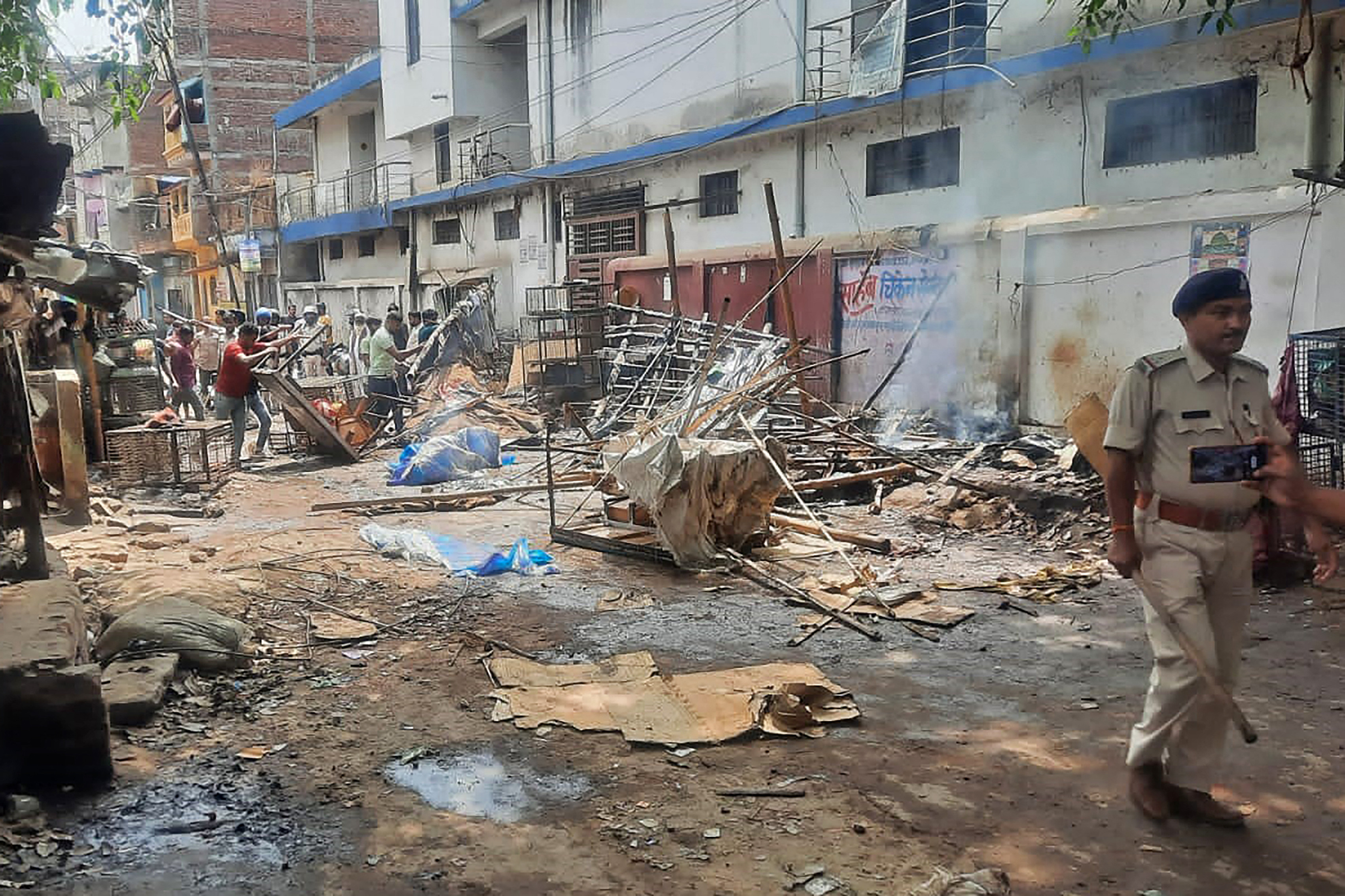 a policeman r walks through a street after a violent clash at sasaram in india s bihar state april 1 2023 photo afp